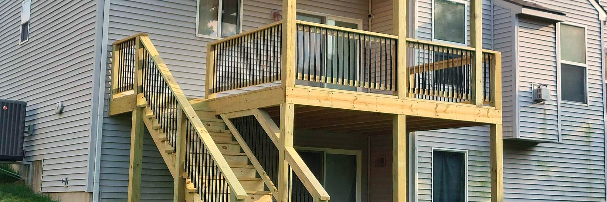 Covered deck with a timber pergola over the upper level of a two-story home.