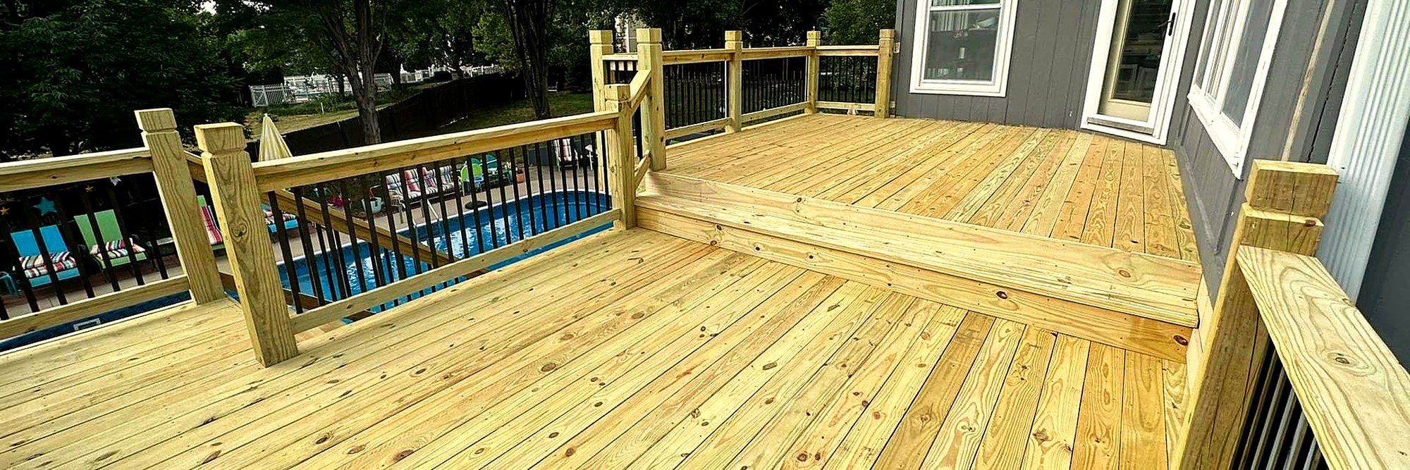 Wide new deck boards running beside an above-ground pool.