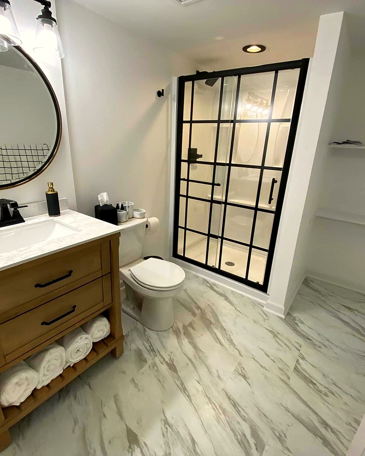 Finished lower-level bathroom with a tiled shower surround and vanity.