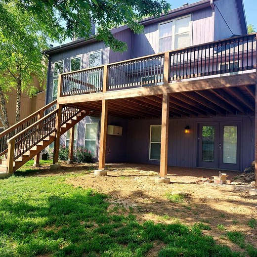 Two-story deck with a stair run on a wooded lot.