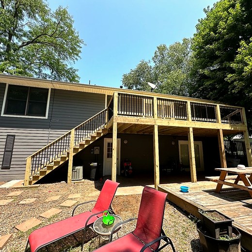 Upper deck with a pergola, seen from a lower patio.