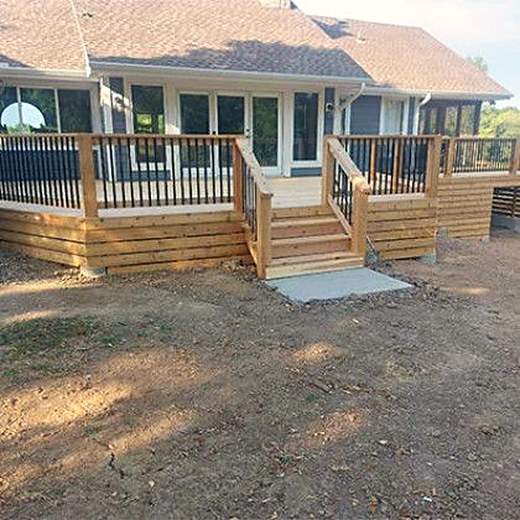 Deck with stairs down to a poured concrete landing pad.