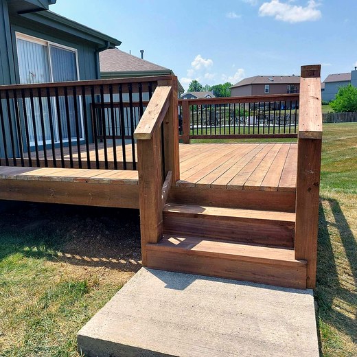 Cedar deck with black aluminum balusters and a stair landing.