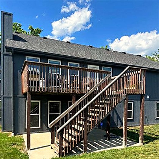 Two-story deck with a long stair run on a dark grey house.