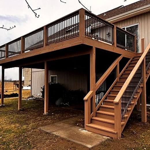 Tall two-story deck with storage underneath and stairs to the yard.