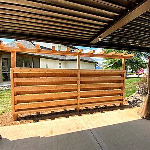 Horizontal slat privacy screen beneath a timber pergola.