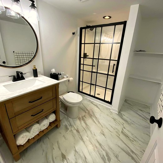 Finished basement bathroom with a glass shower and vanity.