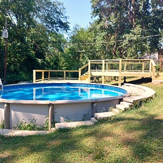 Timber deck wrapping around an above-ground pool.