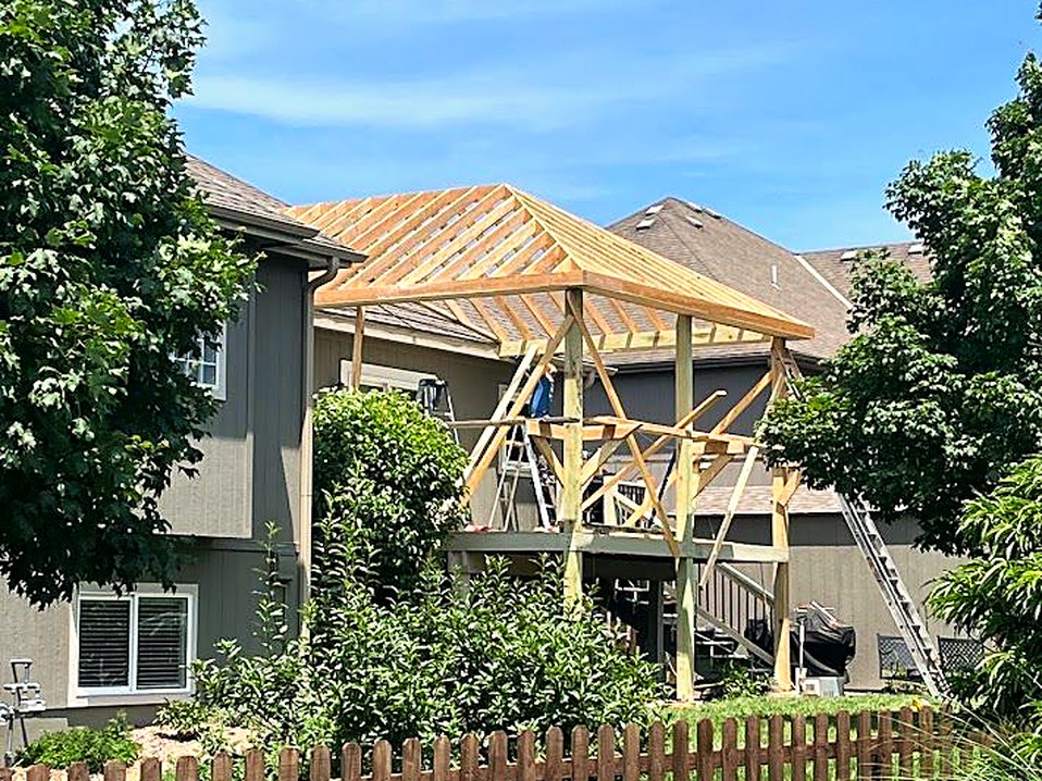 Roof framing going up over the new porch structure.