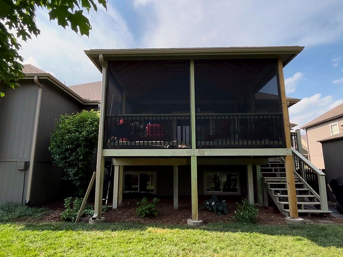 Finished screened-in porch on the rear of a two-story house.